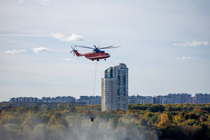 Пожарный вертолет набирает воду в Москве-реке для тушения возгорания