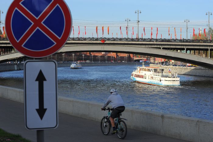 Велосипедист едет по набережной Москвы-реки