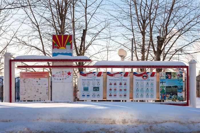 Портреты лучших спортсменов спортшколы «Орбита» на Доске почета в городе Дзержинский зимой