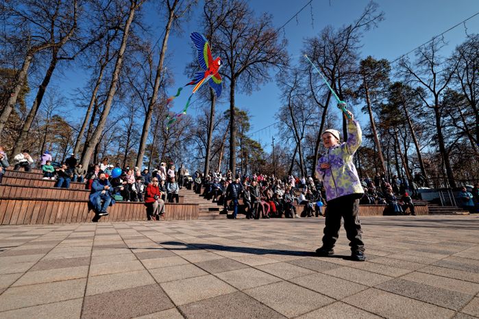 Ребенок запускает воздушного змея на праздновании 100-летия города Раменское в Городском парке культуры и отдыха