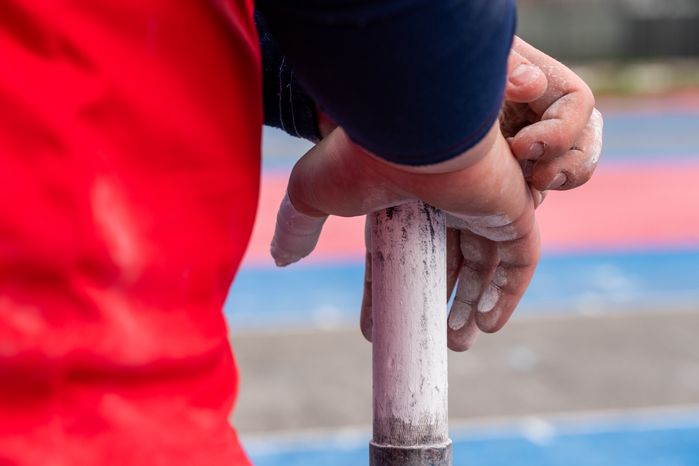 Спортсмен держит в руке биту для городошного спорта