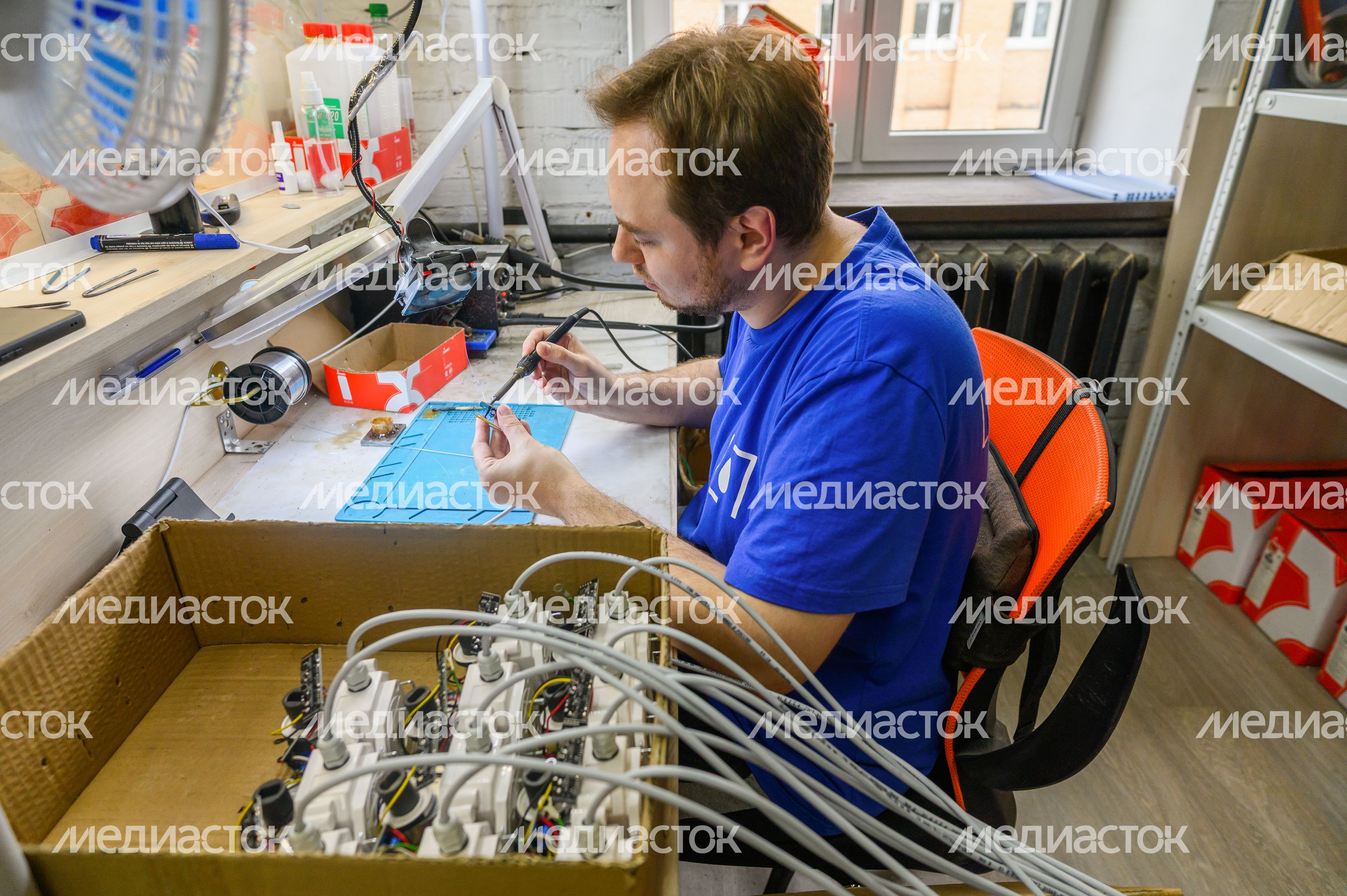 Рабочий собирает шаровый кран с электроприводом для система защиты от протечек воды Gidrolock от производителя из Мытищ