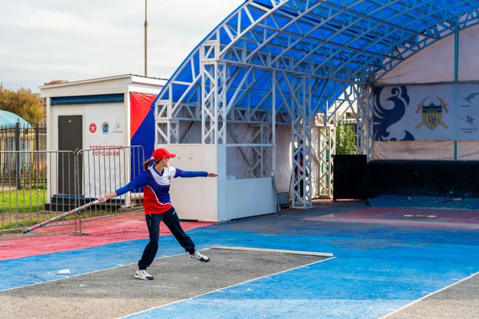 Спортсменка из России кидает биту на соревнованиях по городошному спорту в Подольске