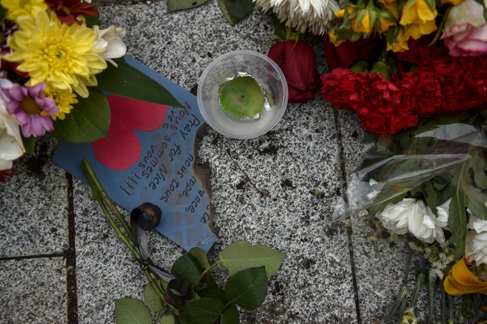Жители Москвы несут цветы к посольству Франции
