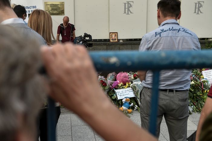 Жители Москвы несут цветы к посольству Франции
