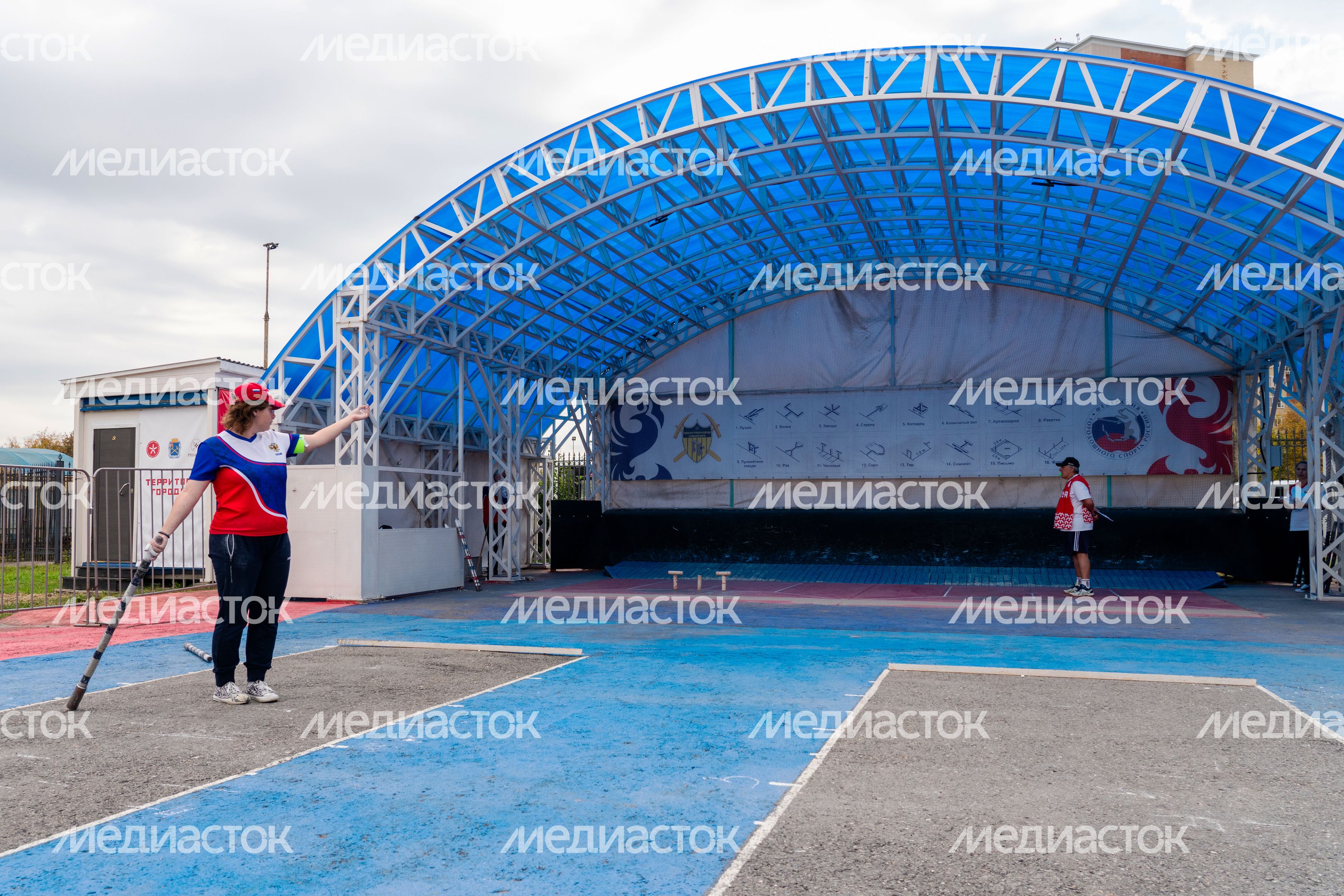 Спортсменка из России кидает биту соревнованиях по городошному спорту в Подольске