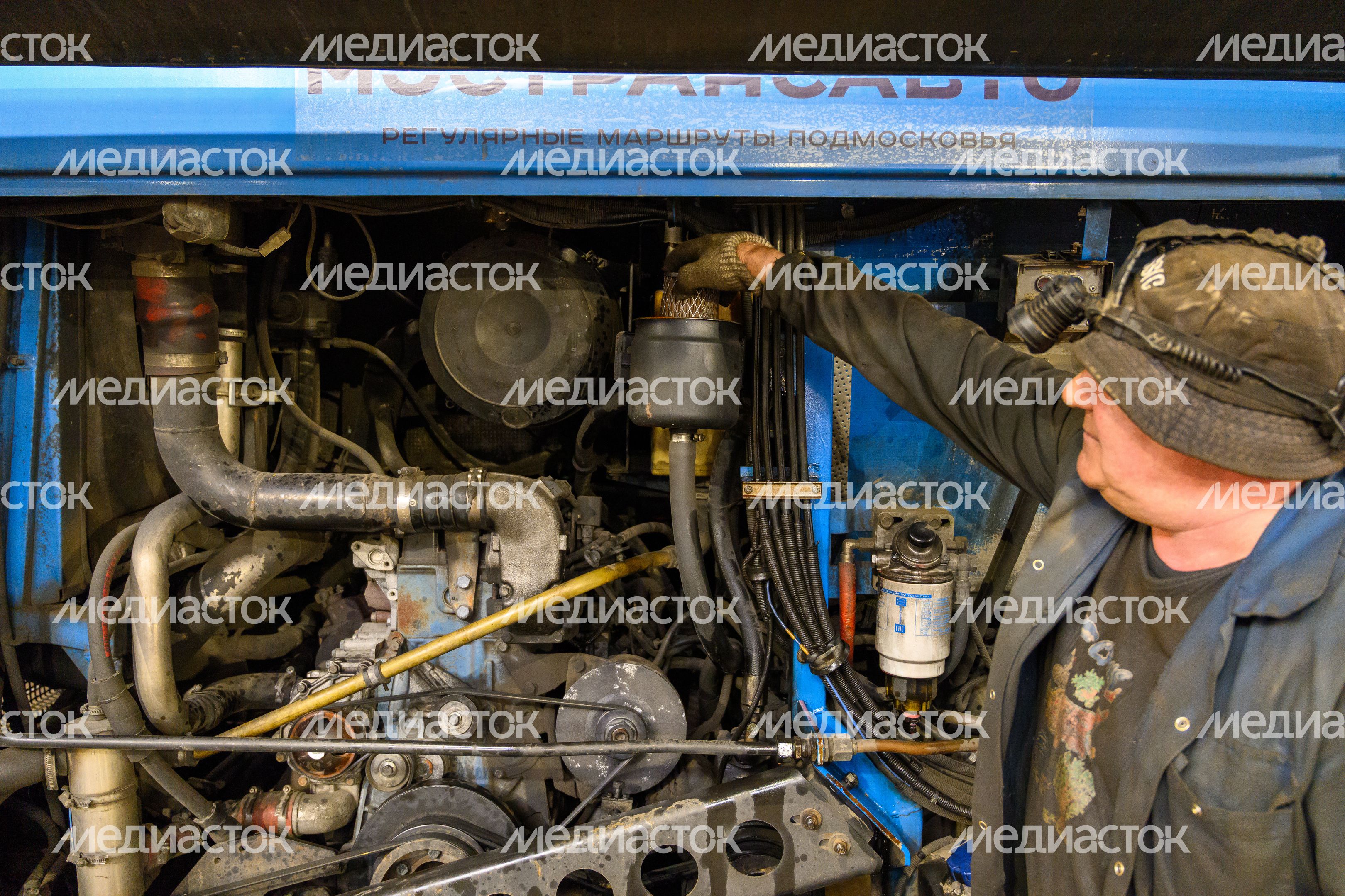 Автомеханик проводит технический осмотр автобуса перед отправлением в рейс