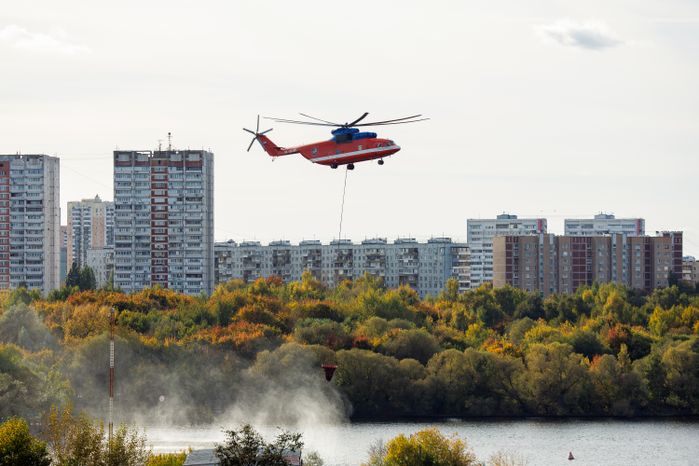 Пожарный вертолет набирает воду в Москве-реке для тушения возгорания