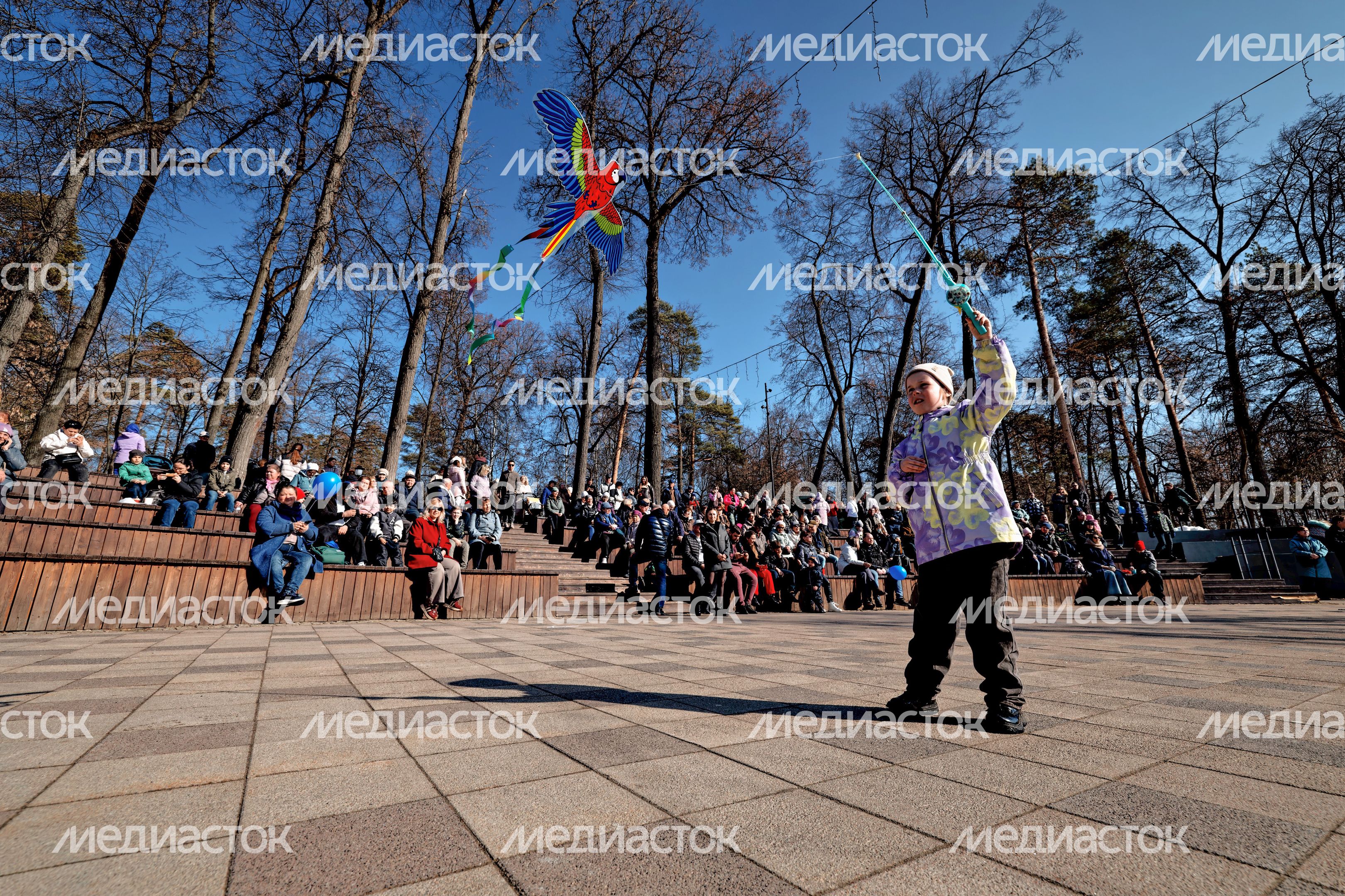 Ребенок запускает воздушного змея на праздновании 100-летия города Раменское в Городском парке культуры и отдыха Ребенок запускает воздушного змея на праздновании 100-летия города Раменское в Городском парке культуры и отдыха