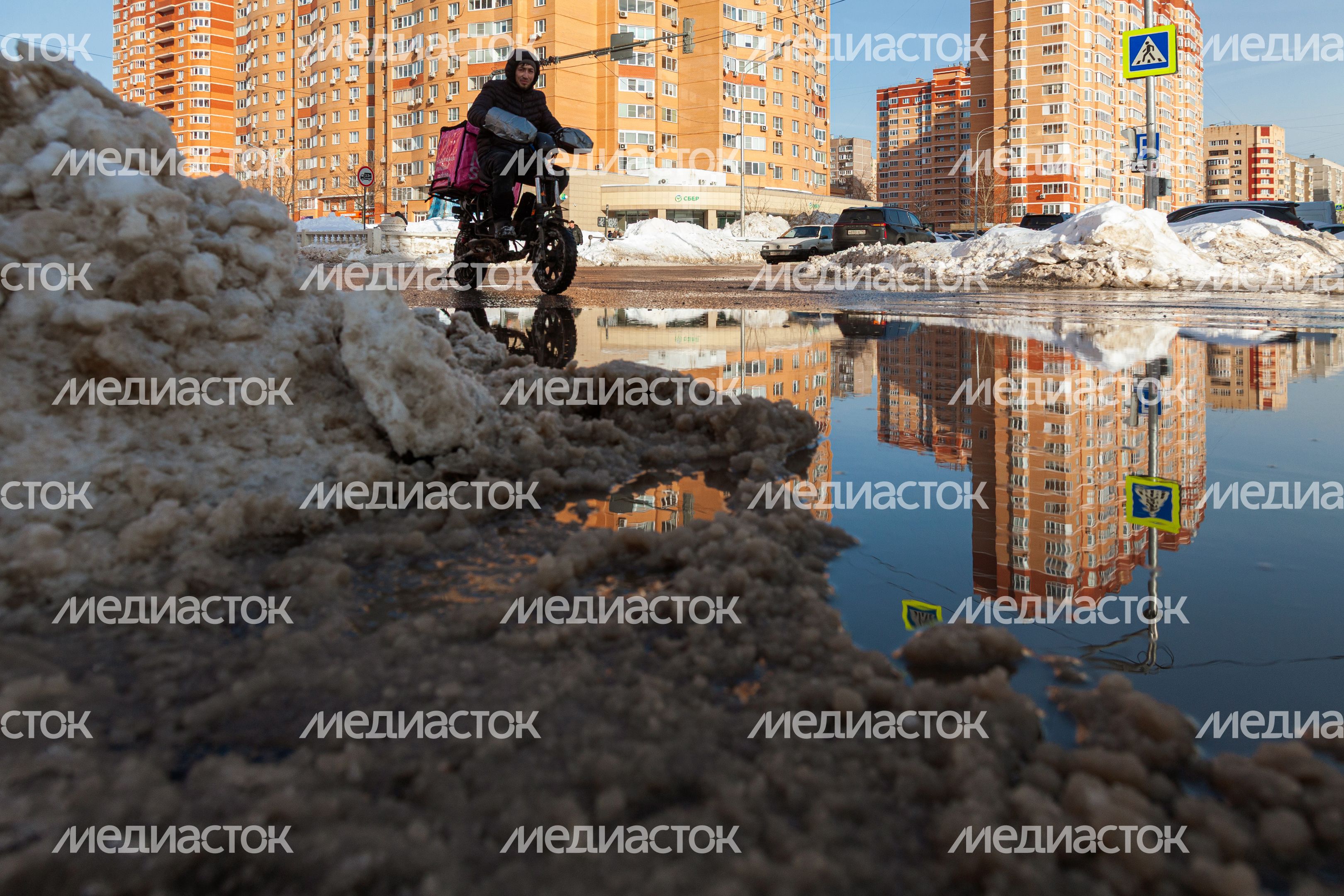 Курьер едет на электрическом велосипеде в Дзержинском