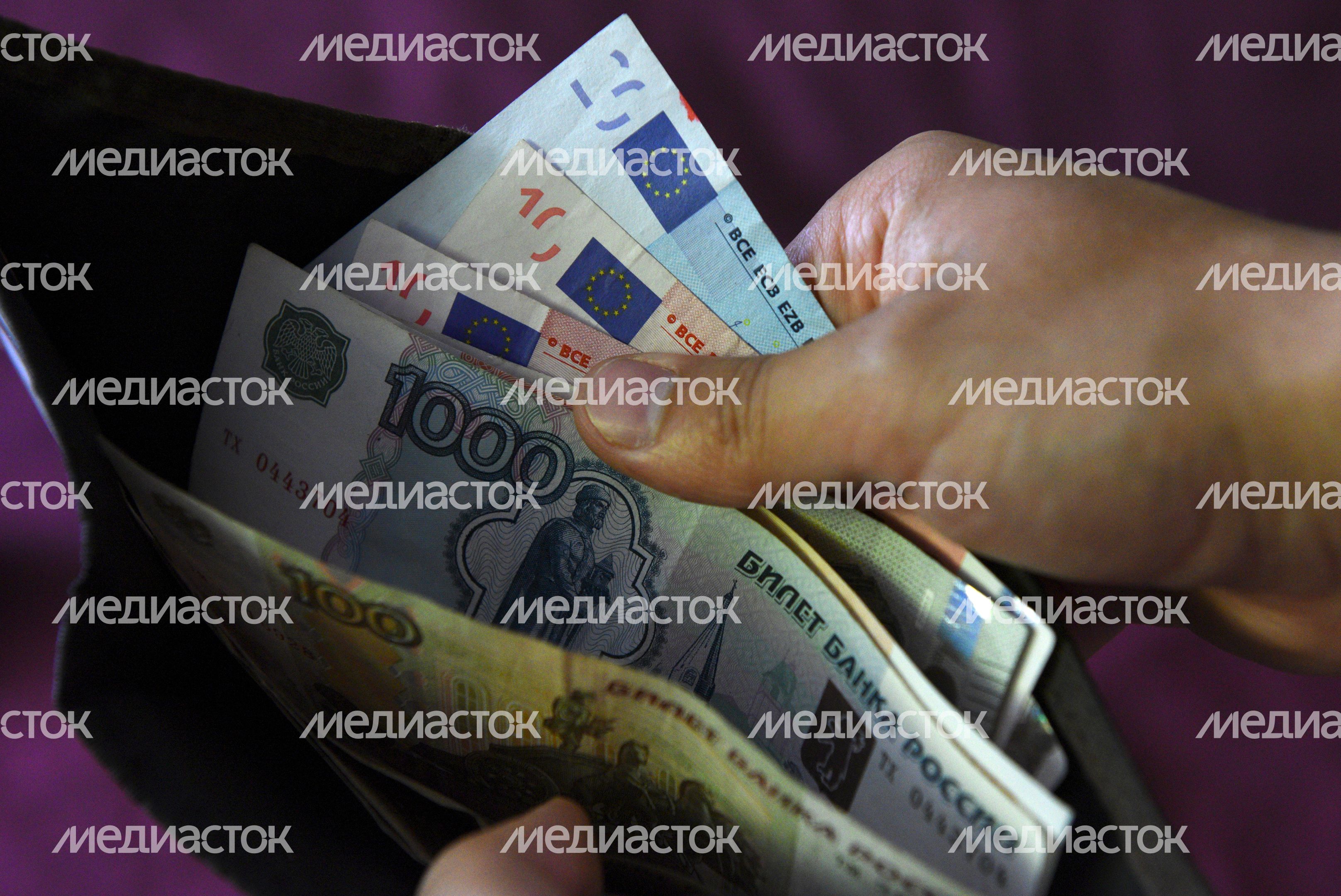 Денежные купюры евро и рублей в кошельке Денежные купюры евро и рублей в кошельке