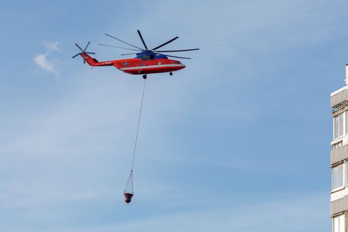 Пожарный вертолет набирает воду в Москве-реке для тушения возгорания