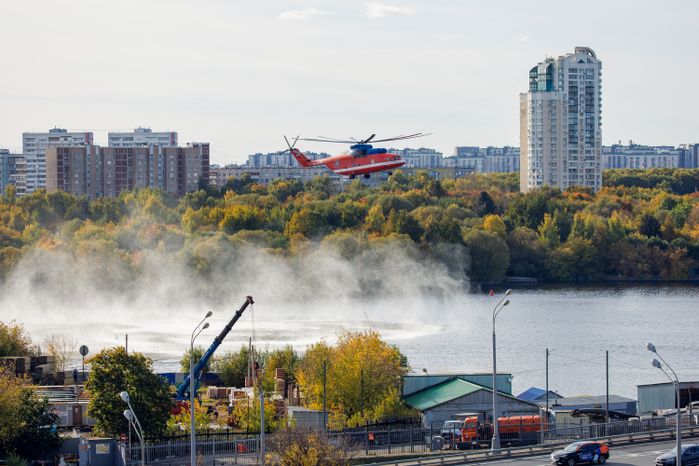 Пожарный вертолет набирает воду в Москве-реке для тушения возгорания