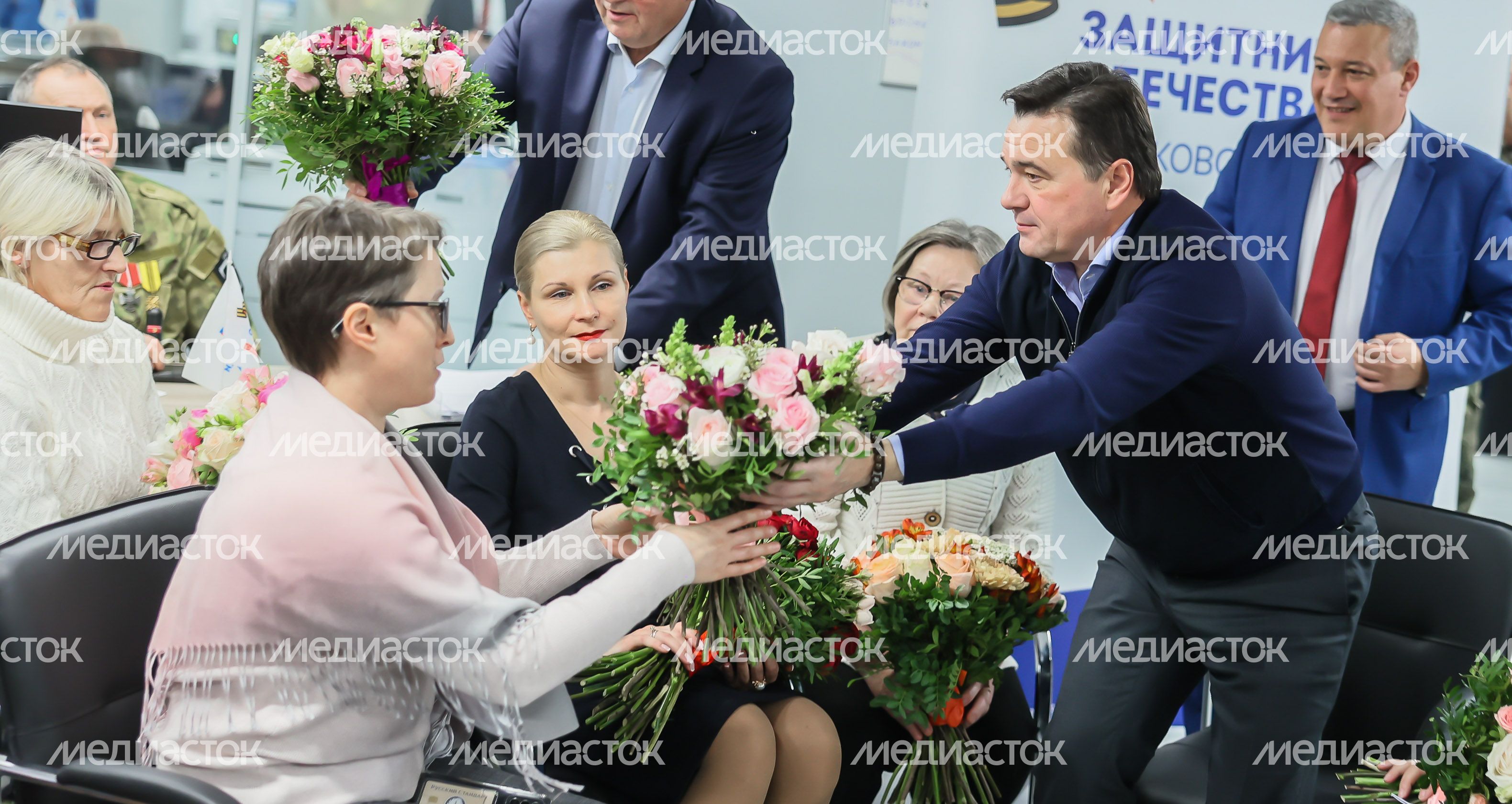 Андрей Воробьев вручает цветы матери участника СВО