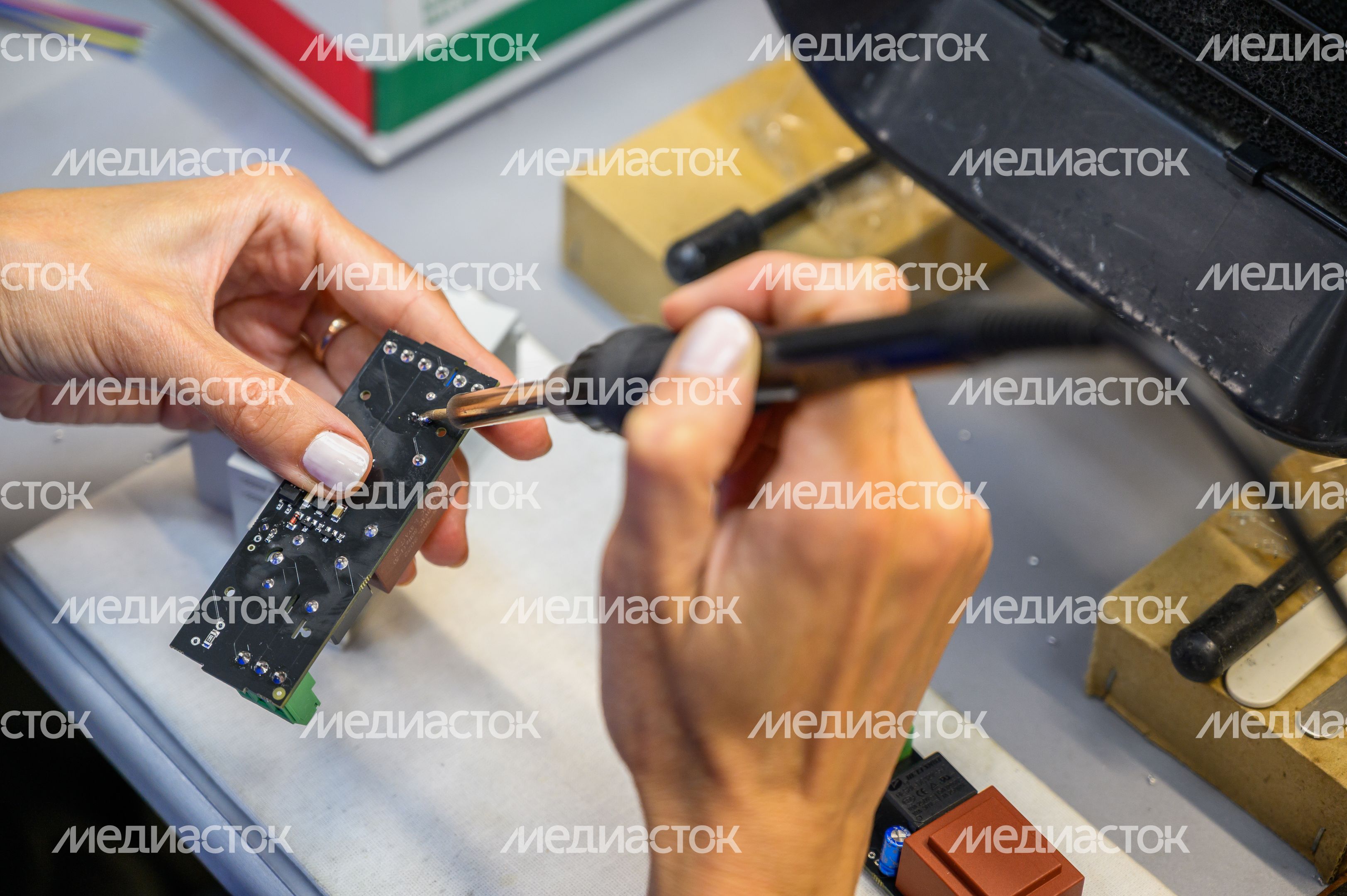 Специалист паяет микросхему электропривода шарового крана для системы защиты от протечек воды Gidrolock