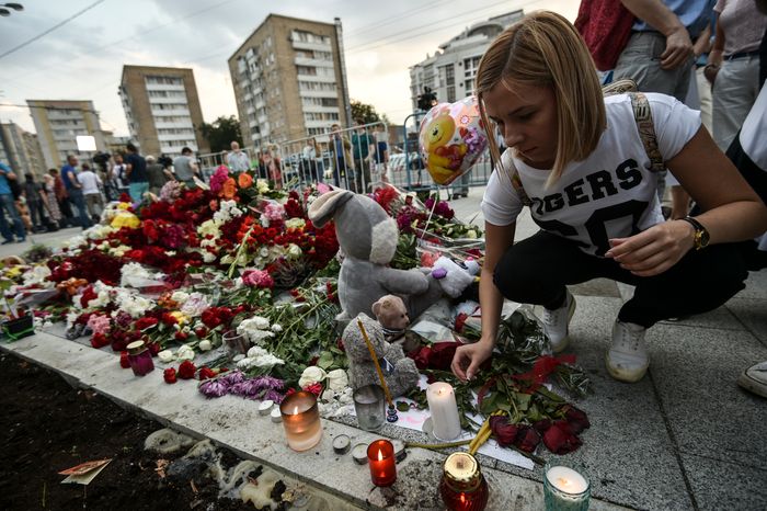 Жители Москвы несут цветы к посольству Франции