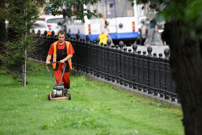 Газонокосильщик стрижет траву на Тверском бульваре в Москве