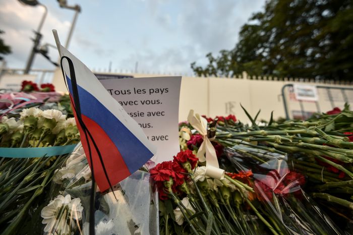 Жители Москвы несут цветы к посольству Франции