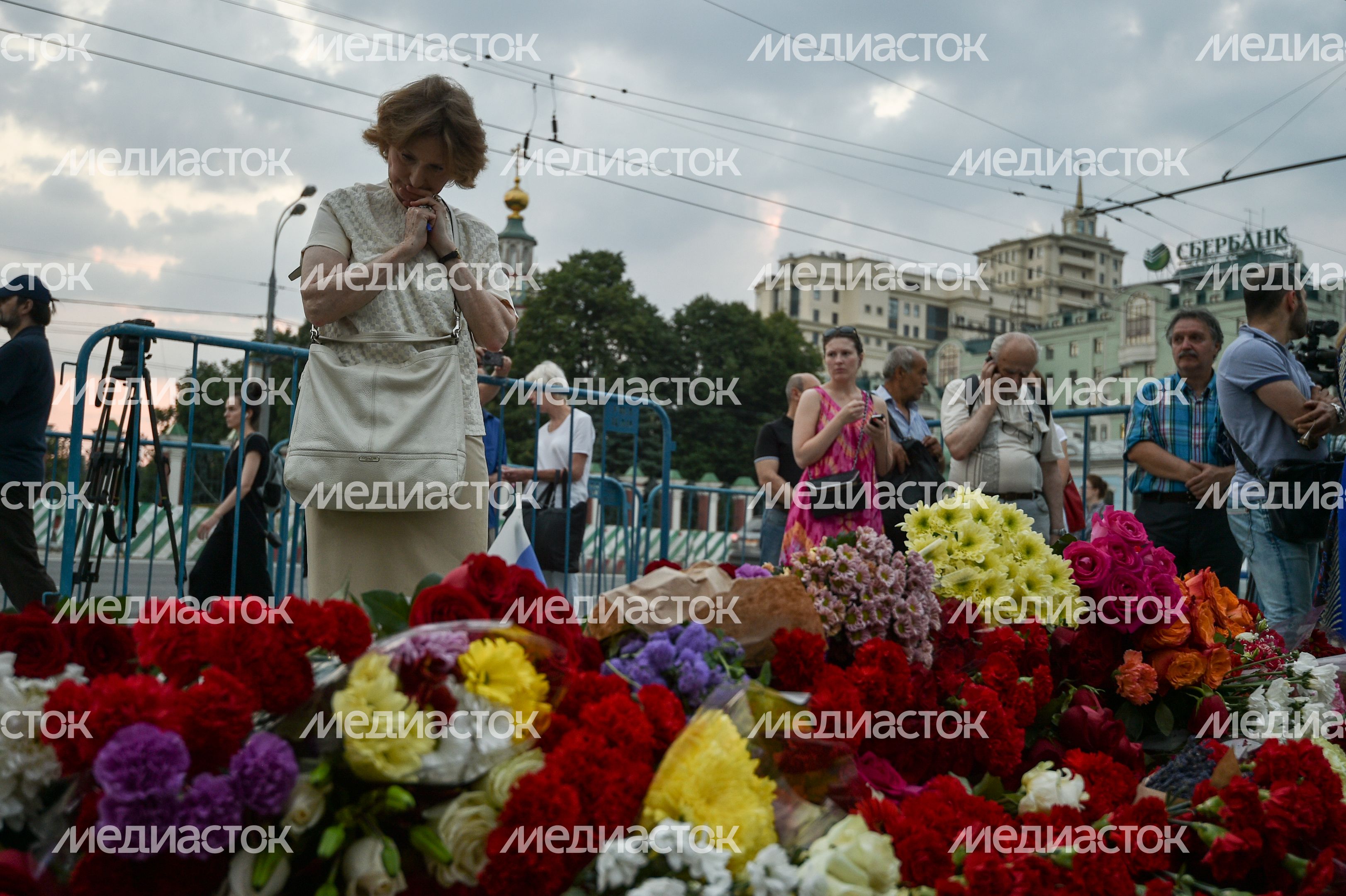 Жители Москвы несут цветы к посольству Франции
