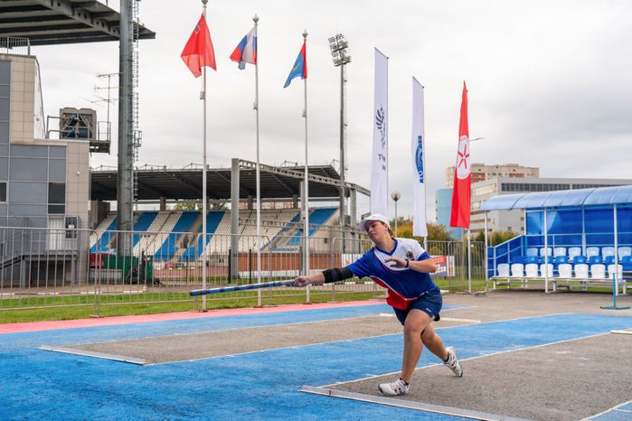 Спортсменка из России кидает биту на соревнованиях по городошному спорту в Подольске