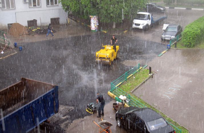Укладка асфальта во время дождя в Лобне