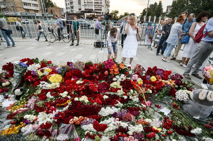 Жители Москвы несут цветы к посольству Франции