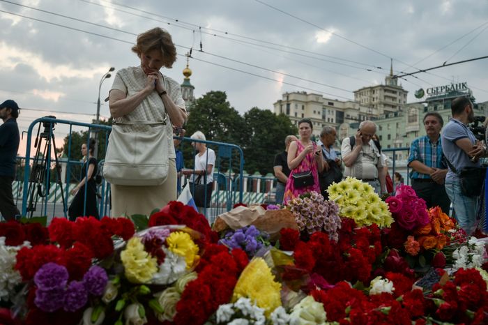Жители Москвы несут цветы к посольству Франции