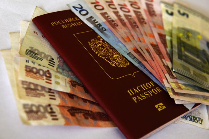 Денежные купюры рублей и евро, и заграничный паспорт