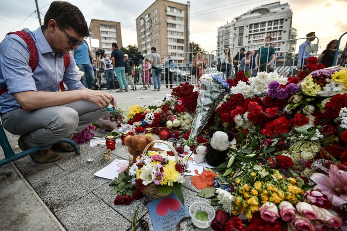 Жители Москвы несут цветы к посольству Франции