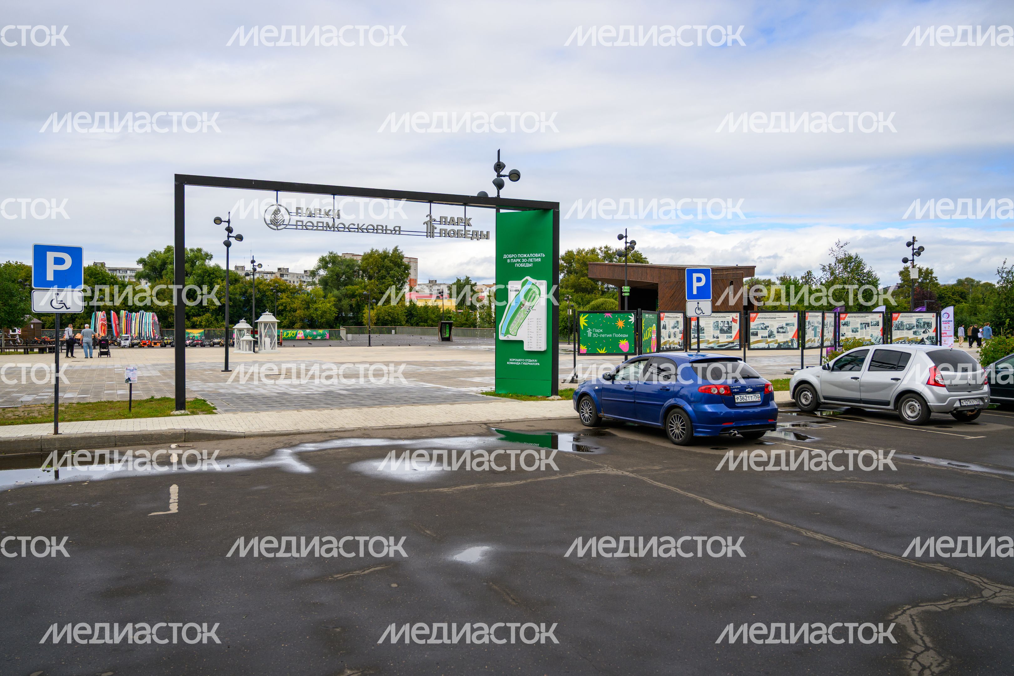 Парковка для автомобилей в парке 30-летия Победы летом в Орехово-Зуево Парковка для автомобилей в парке 30-летия Победы летом в Орехово-Зуево