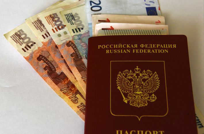 Денежные купюры рублей и евро, и заграничный паспорт