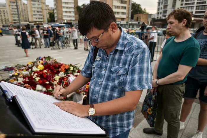 Жители Москвы несут цветы к посольству Франции