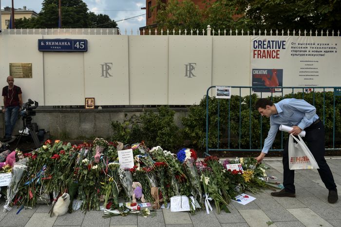 Жители Москвы несут цветы к посольству Франции