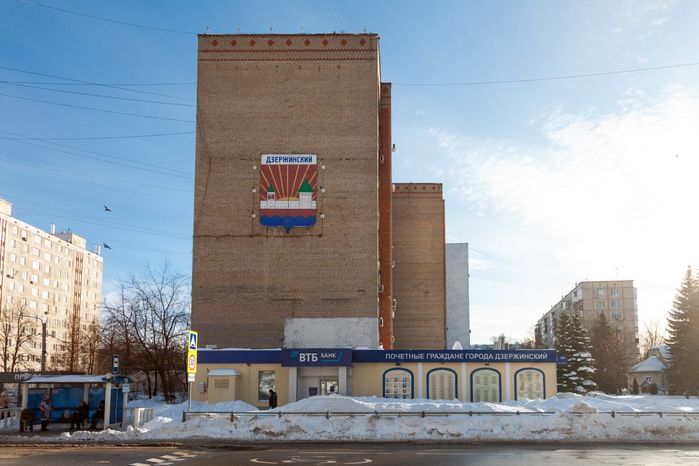 Герб города Дзержинский на стене дома